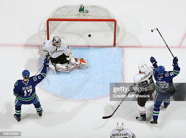 Toni Lydman of the Anaheim Ducks looks on as Ryan Kesler and Henrik Sedin of the Vancouver Canucks celebrate their goal on Curtis McElhinney of the...