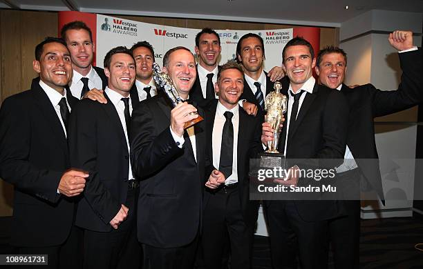 New Zealand Prime Minister John Key poses with the All Whites team after winning the supreme award during the Westpac Halberg Awards at the SkyCity...