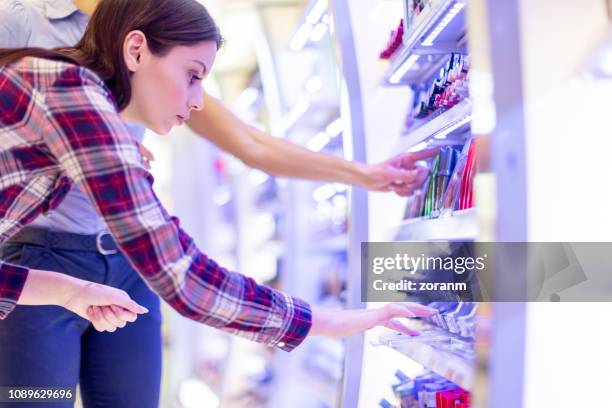 touching make-up on the stand in pharmacy - cosmetic testing store stock pictures, royalty-free photos & images