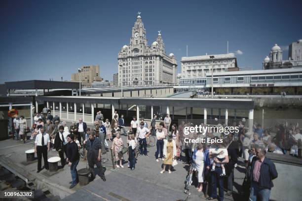 Crowds wait to board a Birkenhead ferry to cross the river Mersey, Liverpool, June 1982.