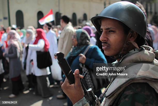An Egyptian army soldier watches as doctors, medical workers and students march through Cairo to join anti-government protests in Tahrir Square on...