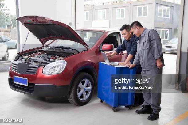 chinese mechanics working on laptop - car hood stock pictures, royalty-free photos & images