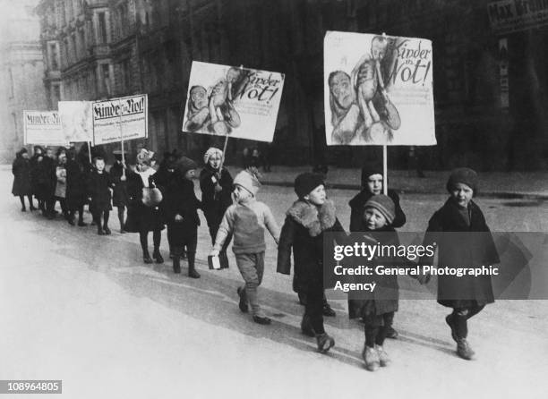 Children of wealthy parents march in Berlin to highlight the extent of poverty among the city's children, circa 1930. Their placards read 'Kinder In...