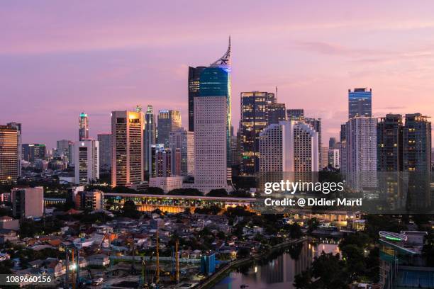 sunset over business district jakarta skyline - jakarta stock pictures, royalty-free photos & images