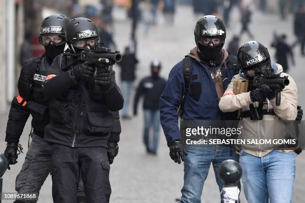 Riot police officers aim at protesters with rubber bullets less lethal gun during an anti-government demonstration called by the Yellow Vests "Gilets...