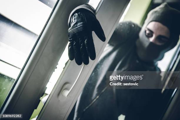 inbreker breken in huis - breaking window stockfoto's en -beelden