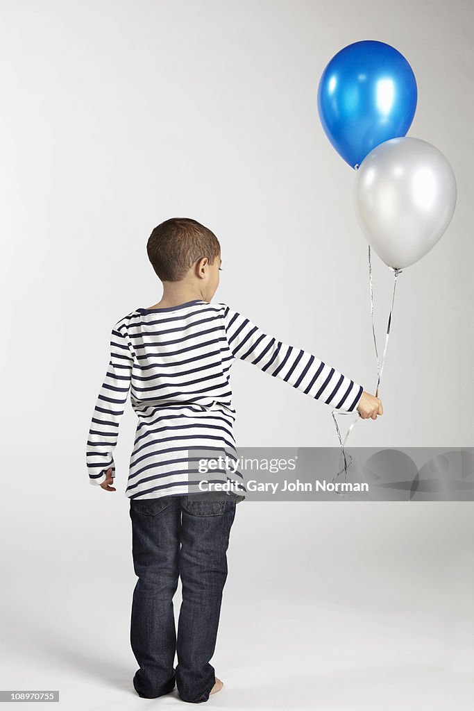 Boy holding ballons