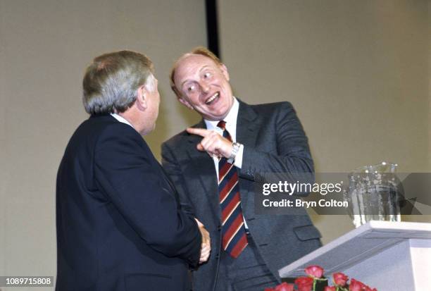 Neil Kinnock, leader of the Labour Party and member of Parliament, right, gestures to Roy Hattersley, deputy leader of the Labour Party and member of...