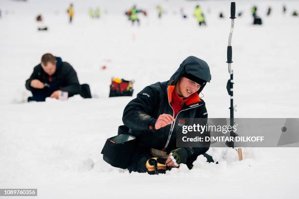 An angler from Bealrus team takes part in the XVI World Ice Fishing Championship in Shiroka Polyana dam near Batak on January 26, 2019. - They...