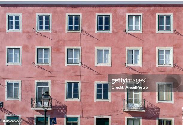 red facade with twenty-four windows - red wall stockfoto's en -beelden