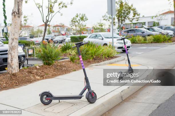 Pink and purple sharing economy rentable scooters from ridesharing company Lyft are parked along a road in the Marina Del Rey neighborhood of Los...