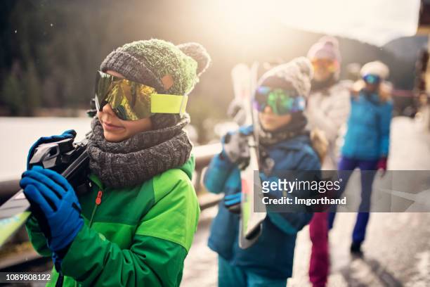 family walking with skis on sunny winter day - friends skiing stock pictures, royalty-free photos & images