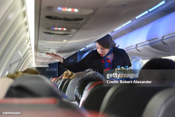 An American Airlines flight attendant serves drinks to passengers after departing Dallas/Fort Worth International Airport.