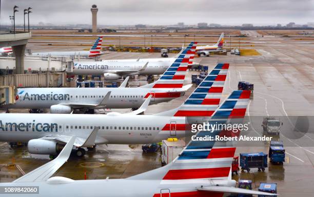 American Airlines passenger jets parked at their gates on a rainy morning at Dallas/Fort Worth International Airport which serves the Dallas/Fort...