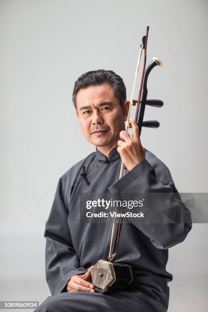 male artist in the erhu - chinesischer kragen stock-fotos und bilder