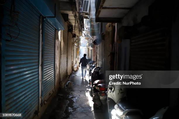 Man walks past the alley with shutters down in the bustling market of Old Delhi. On 26 January 2019 in Delhi, India.