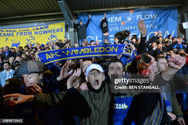 Wimbledon fans celebrate their victory at the end of the English FA Cup fourth round football match between AFC Wimbledon and West Ham United at...