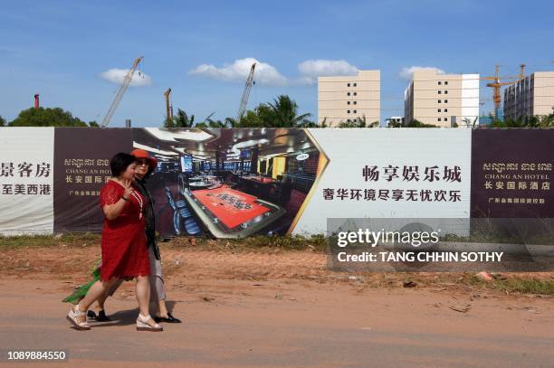 This photo taken on December 14, 2018 shows Chinese tourists walking along a construction site for a hotel and casino in Sihanoukville, the coastal...