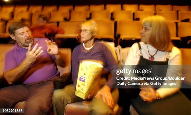 Bob Furman talks using sign language with his wife Ginny Furman and Marie Cacciator before the start of Pirates of the Caribbean at the Colony Square...