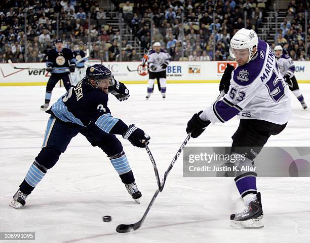 Alec Martinez of the Los Angeles Kings attempts clearing the puck past Alex Goligoski of the Pittsburgh Penguins at Consol Energy Center on February...