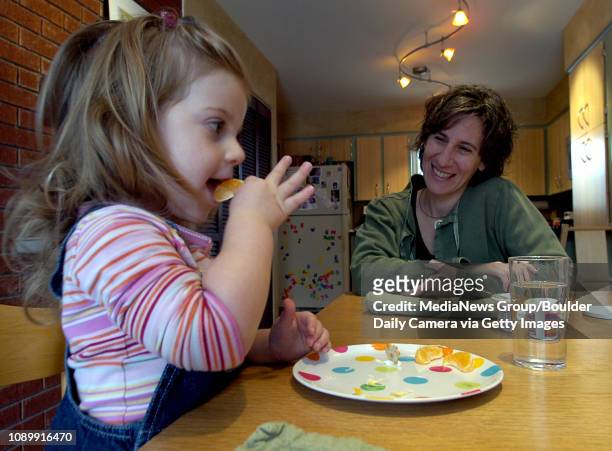 Dena Nishek watches her daughter, Elli eat a snack of organic clementines and whole wheat crackers in their home December 12, 2006 at the Boulder...