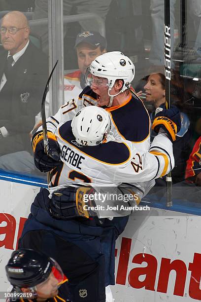 Tyler Myers is congratulated by Nathan Gerbe of the Buffalo Sabres after scoring the winning goal in overtime against the Florida Panthers on...