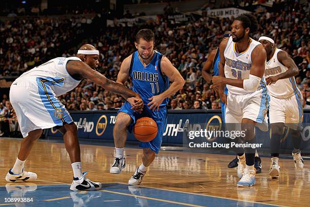 Jose Barea of the Dallas Mavericks has the ball knocked away by Al Harrington of the Denver Nuggets as Nene follows the play during NBA action at the...