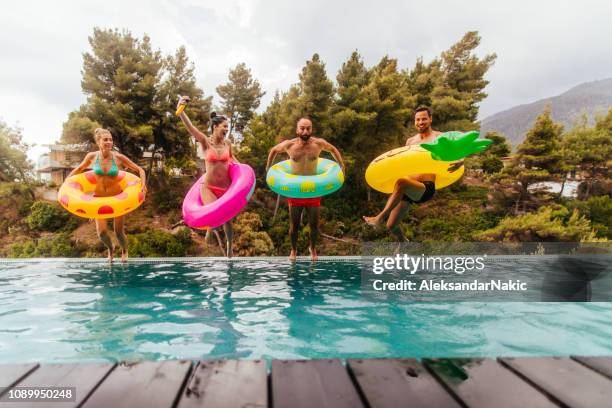 vrienden zijn springen in het zwembad - luxury europe vacation stockfoto's en -beelden