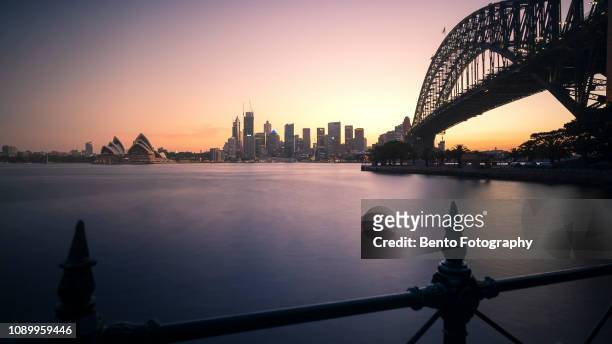 long exposure opera house with harbour bridge in sunset, sydney, australia - australia sydney opera house stock pictures, royalty-free photos & images