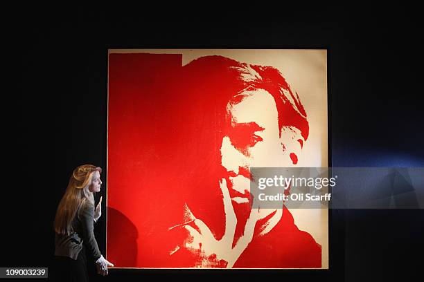 An employee at Christie's auction house views a self-portrait painting by Andy Warhol on February 11, 2011 in London, England. The giant...