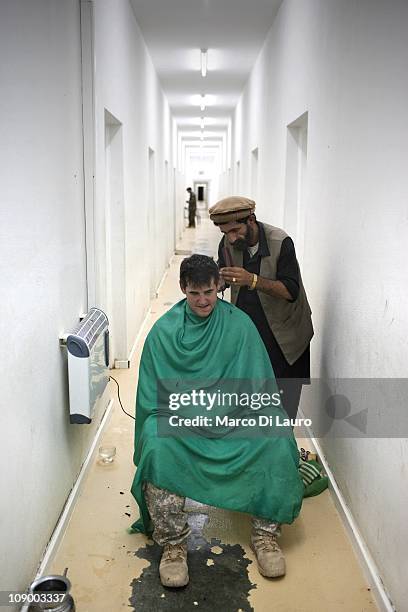 An Afghan barber cuts the hair to US army SSG Ryan Hern, 27 from Georgia, Alpha Company 1/121 Infantry , 48th BCT part of the Embedded Training Team...