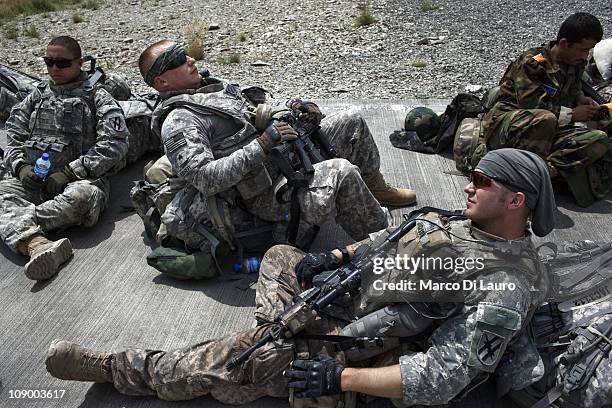 Army soldiers from the Alpha Company 1/121 Infantry , 48th BCT and US Army Embedded Training Team and Human Terrain Team wait on a landing strip for...