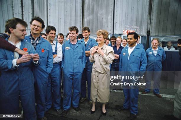 Glenys Kinnock, wife of Labour party leader Neil Kinnock, is given a "Vote Labour" sticker by workers at the British Aerospace factory during the...