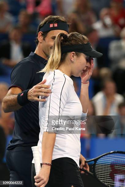 Roger Federer of Switzerland consoles Belinda Bencic during the mixed doubles match against Alexander Zverev and Angelique Kerber of Germany day...