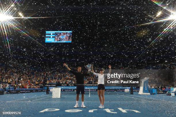 Roger Federer and Belinda Bencic of Switzerland pose with the Hopman Cup after winning the final against Alexander Zverev and Angelique Kerber of...