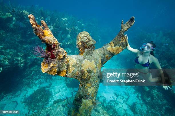 snorkeler with bronze statue of christ. - snorkel reef stockfoto's en -beelden