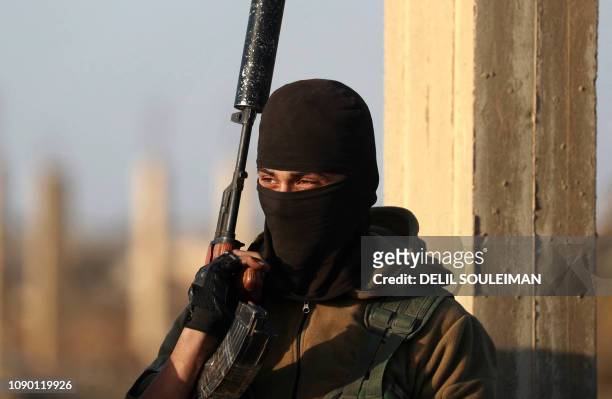 Fighter of the Syrian Democratic Forces keeps watch in the Syrian village of Baghuz in the countryside of the eastern Deir Ezzor province on January...