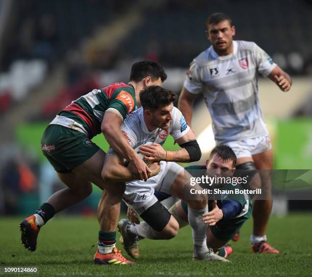 Owen Williams of Gloucester Rugby is tackled by Matt Toomua and Will Evans of Leicester Tigers during the Gallagher Premiership Rugby match between...