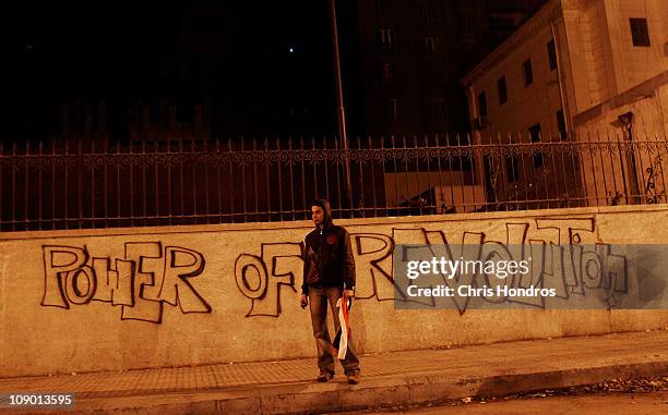 Young reveler stands in front of graffiti in Tahrir Square during celebrations after President Hosni Mubarak stepped down, February 11, 2011 in...