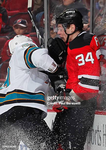 Ryane Clowe of the San Jose Sharks checks Mark Fayne of the New Jersey Devils during the first period of an NHL hockey game on February 11, 2011 at...