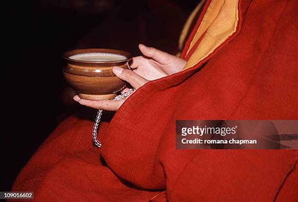 nun holding butter tea in wooden cup - tibet stock pictures, royalty-free photos & images
