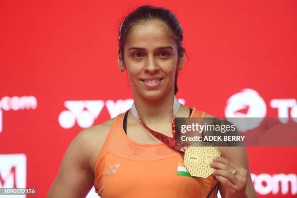 Saina Nehwal of India poses with her winner's medal after Carolina Marin of Spain retired due to injury in their women's singles final match at the...