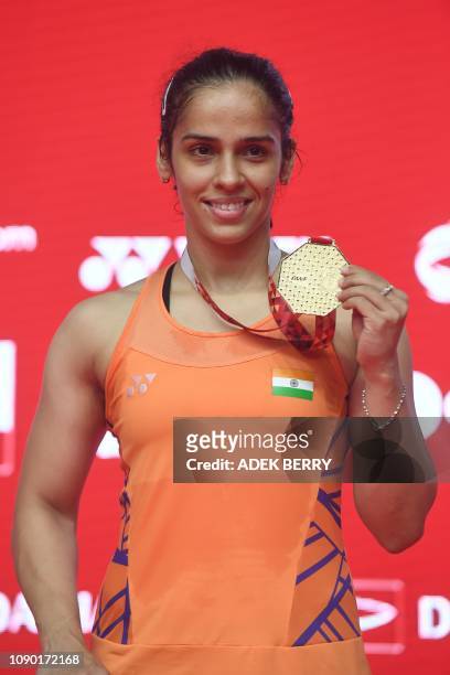 Saina Nehwal of India poses with her winner's medal after Carolina Marin of Spain retired due to injury in their women's singles final match at the...