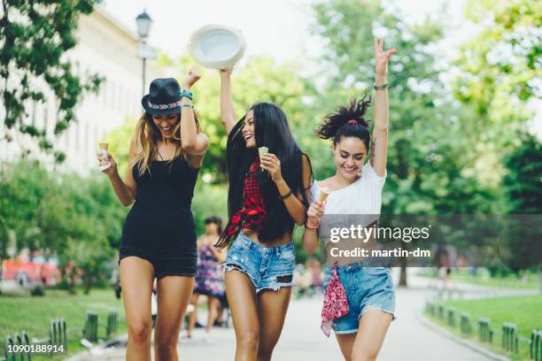 happy girls eating ice-cream and having fun - three people dancing stock pictures, royalty-free photos & images