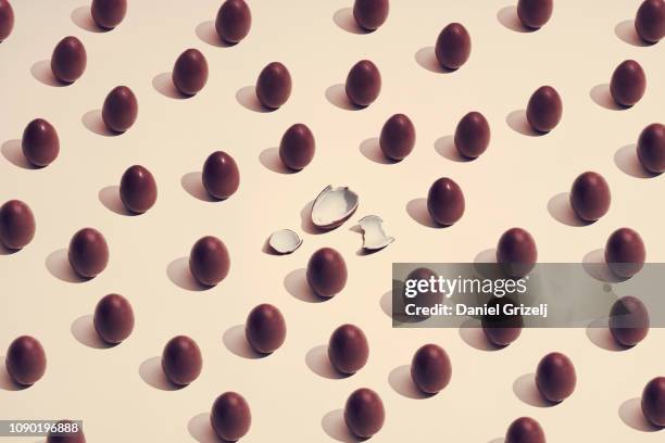 multiple chocolate eggs placed in a pattern, one of a kind - paaseieren stockfoto's en -beelden