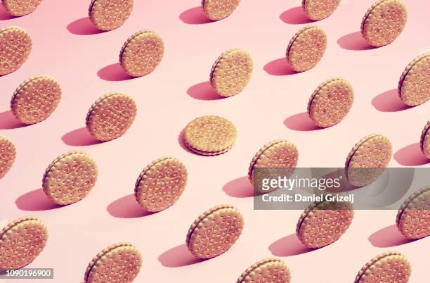 biscuits placed in a pattern on a colored background, one of a kind - ripetizione foto e immagini stock