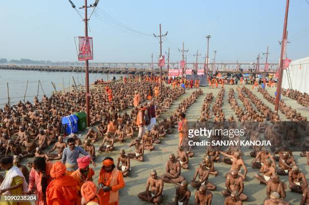 Newly initiated 'Naga Sadhus' sit as they perform rituals on the banks of the Ganges River during the Kumbh mela festival, in Allahabad on January...