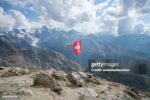 bandera suiza encima de hermoso paisaje de montaña en los alpes suizos en el graubunden cantón - swiss flag fotografías e imágenes de stock