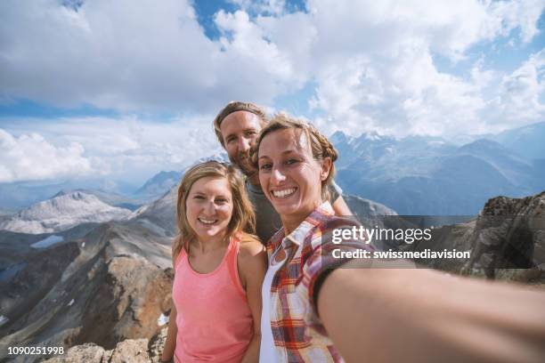 drei junge leute wandern im sommer und nehmen ein selfie-porträt auf dem gipfel - fun sommer berge stock-fotos und bilder