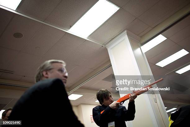 Conference participant plays a shooting game at the National Rifle Association's exhibition booth during the final day of the American Conservative...